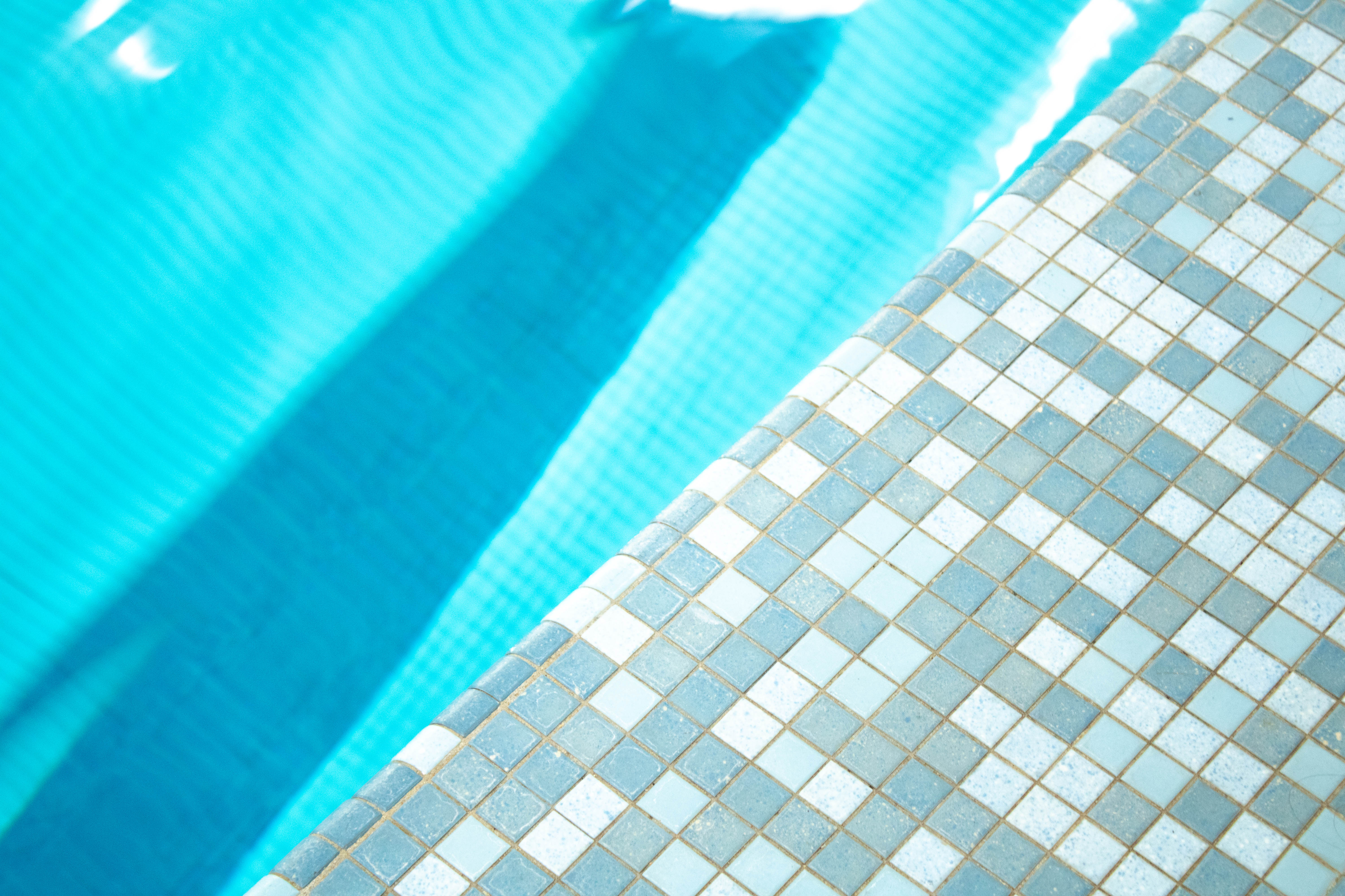 Image of blue square tiling and a clear pool.